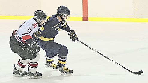 Homer's Tommy Bowe (25) gets to a puck ahead of Juneau-Douglas' Zach Easton (17) during the Crimson Bears 4-1 win over the Mariners on Friday at the Treadwell Arena in Juneau.-KLAS STOLPE