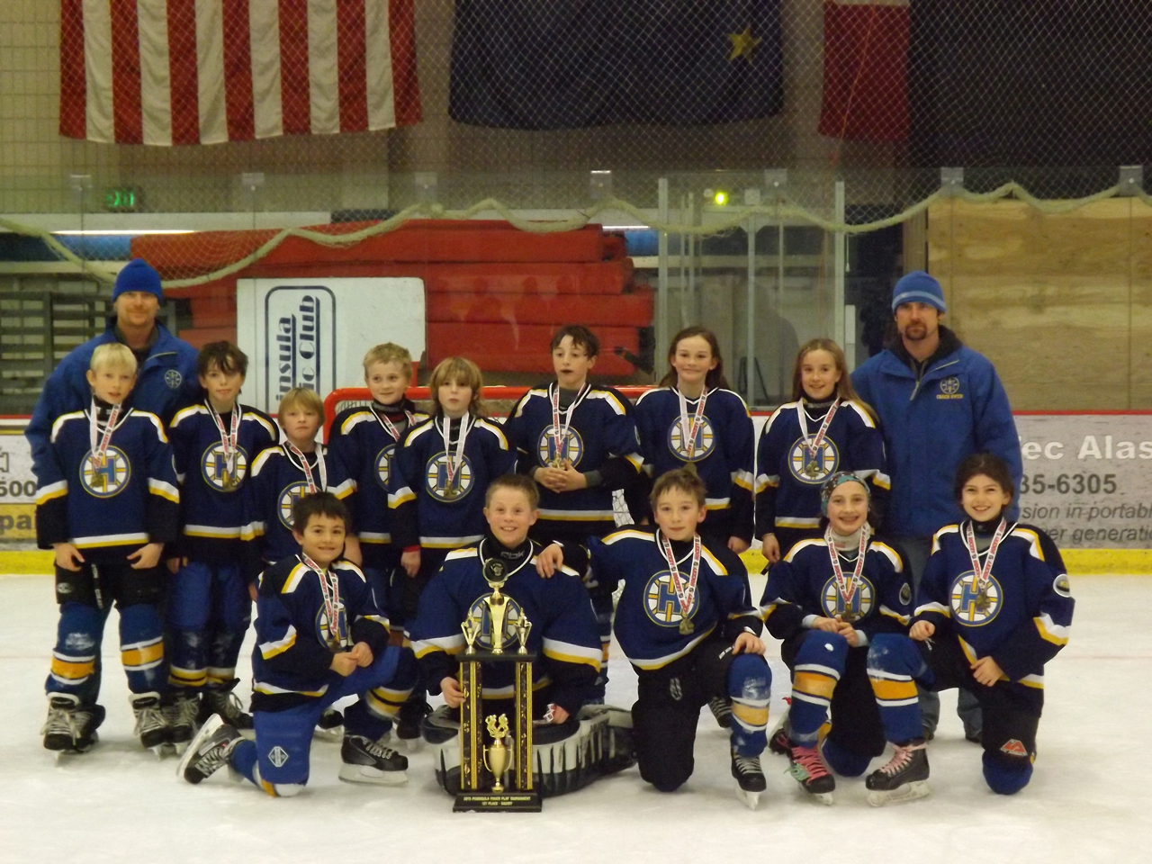 Homer’s Pee Wee C’s gather around their championship trophy from the Power Play Tournament.-Photos by Stephanie Pitzman