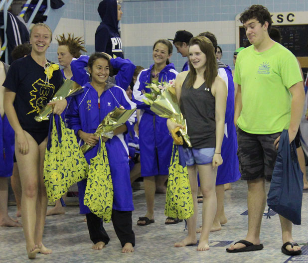With their teammates in the background, Homer High seniors (left to right) Jenna Fabich, Crystal Crane, Cheyanne Smith and Thomas Vanek are honored during the Homer Invitational swim and dive meet on Saturday.-Photos by McKibben Jackinsky, Homer News