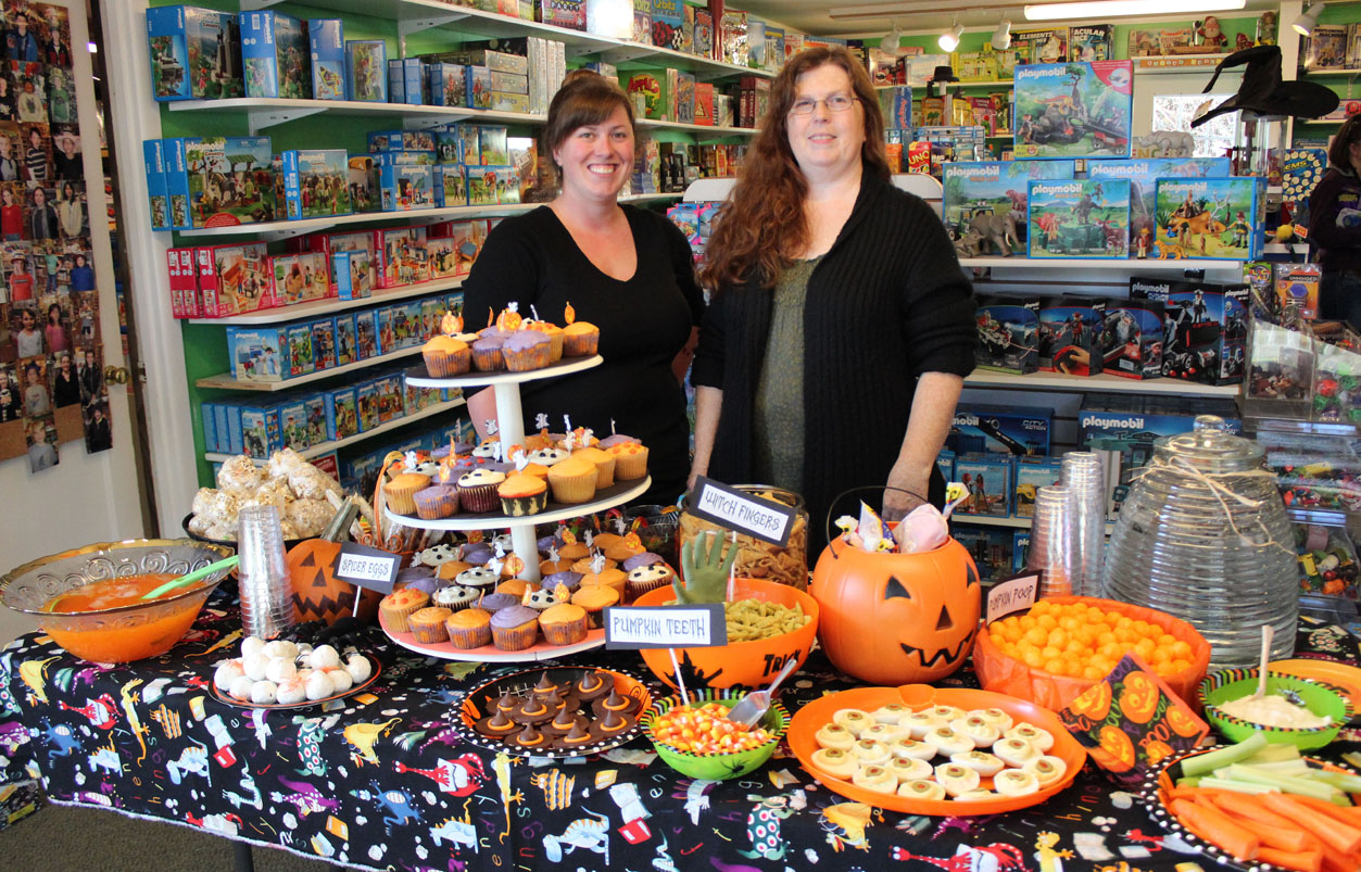 Timeless Toys owner Becky Pheil, right, and her daughter, Marian Ford, serve treats to make any trick-or-treater happy.-Photo by McKibben Jackinsky, Homer News
