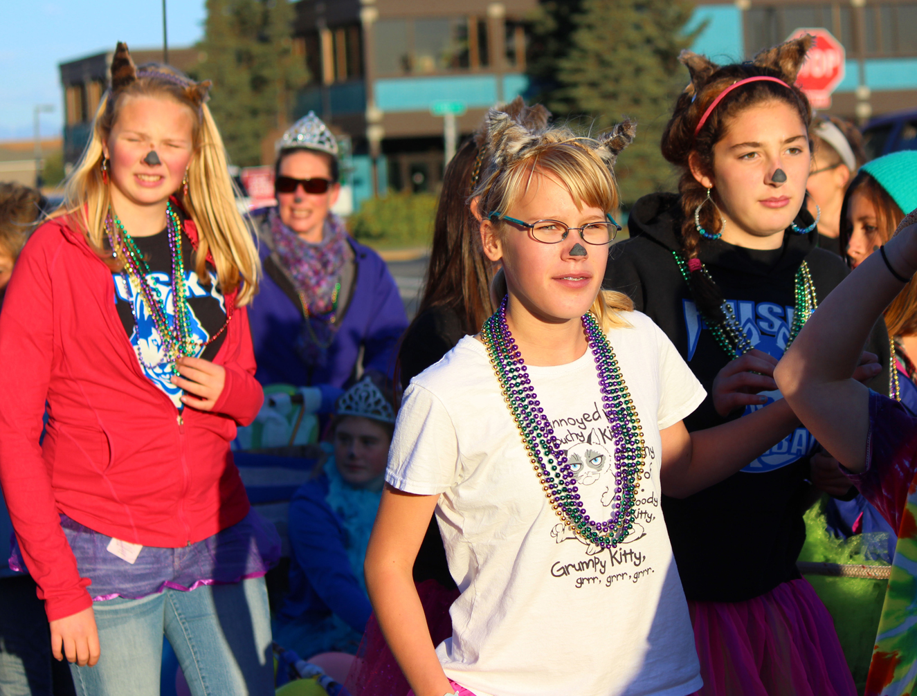Homer Middle School Huskies Cora Parish, Katarina Hockema and Rylyn Todd show their homecoming spirit in Friday night’s Homer High School Homecoming parade. In back, crown-wearing HMS Principal Kari Dendurent adds some sparkle to the parade.-Photo by McKibben Jackinsky, Homer News