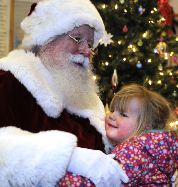 Santa gets a hug from a youngster who