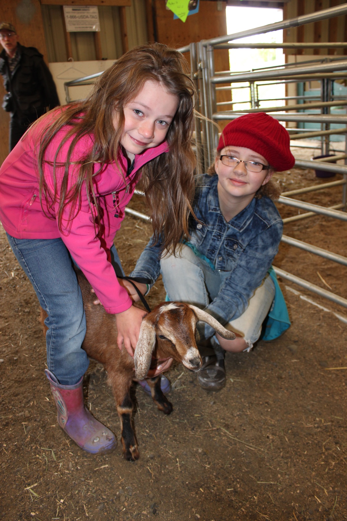 Sisters Angela and Aubrey Duncan of Sterling show off their blue-ribbon goat, Becky, at the Kenai Peninsula Fair.-Photo by McKibben Jackinsky, Homer News