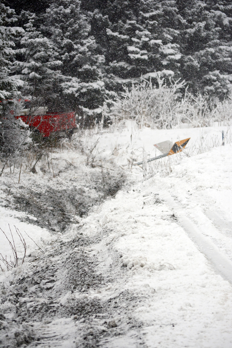 A red truck is in the woods at the side of Diamond Ridge Road last Thursday morning after the driver missed the curve on snowy roads near Sheldon Drive. A woman in the truck said she was shaken up but not hurt and waited for help.-Photo by Michael Armstrong