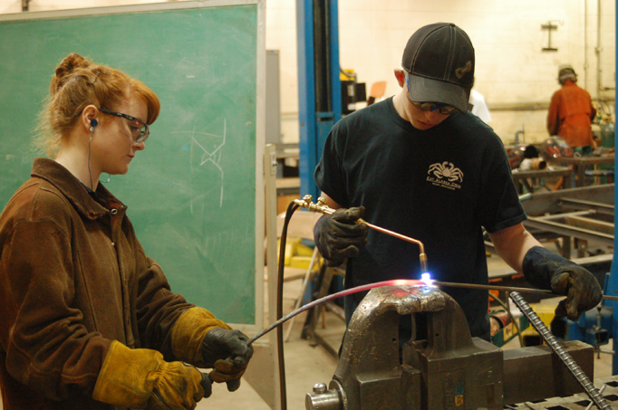 Mady Gerard, left, and Jared Cole, right, students in Mickey Todd’s Homer High School welding class, create the frame for a sculpture being made by Homer Middle School students.