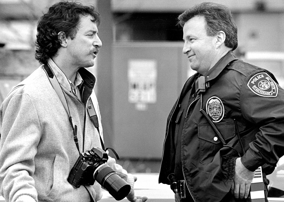 Jim Lavrakas talks with Anchorage Police Department Lt. Bill Casto about access to a crime scene after being barred by another officer in April 1989.-Photo by Paul Souders, Anchorage Daily News