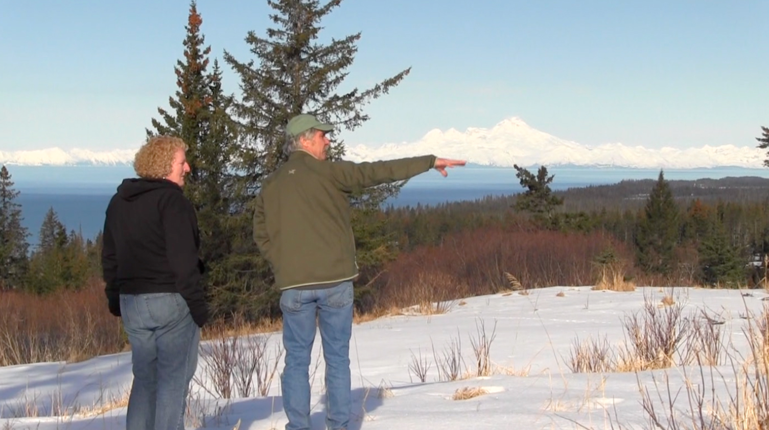 Dana Stabenow, left, and builder Scott Bauer, right, walk Stabenow’s property to select a site for the project. The area includes views of Cook Inlet, Augustine Volcano, Mount Iliamna and Redoubt Volcano.-Photo Provided