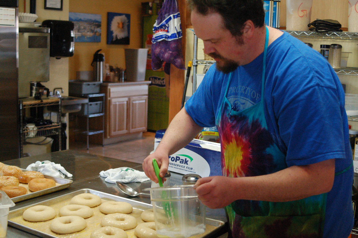 Bagels float in boiling water. Baking soda is mixed with water to make the mixture slightly alkaline. Bagel baker Gabe Chapin said good bagel dough can be judged by how it sinks and then floats in water. Boiling gives bagels the distinctive texture and the pockmarks on the surface.-Photo by Michael Armstrong, Homer News