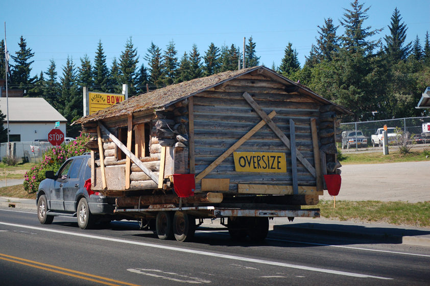 Atz Kilcher drives a truck towing a historic cabin on East End Road on Monday afternoon. The cabin was built by Francis Byer, the builder of the Homestead Restaurant building. Kilcher was moving the cabin to property on West Hill Road where it will be an artist’s studio. -Photo by Michael Armstrong, Homer News