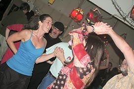 Carey Restino, left, dances at the 2012 New Year's Eve contra dance at Renn Tolman's boat shop.