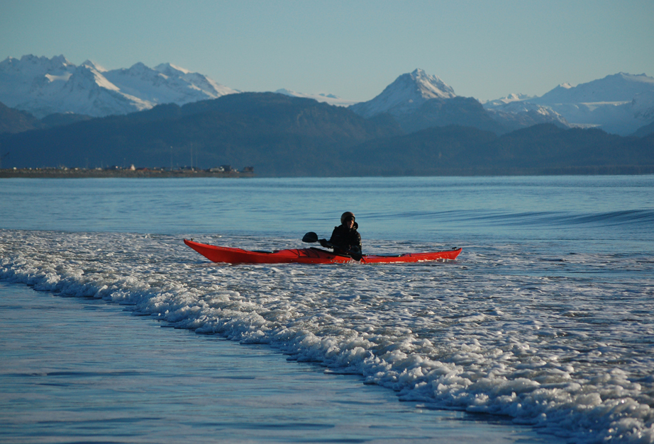 Kim McNett kayaks in a gentle surf off the Homer Spit last week. McNett and partner Bjorn Olsen took advantage of a sunny day to practice their kayak skills.-Photo by Michael Armstrong, Homer News