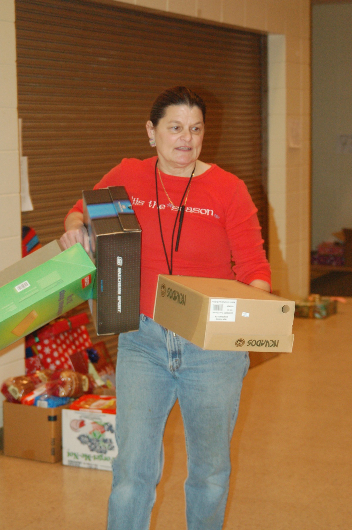 Share the Spirit co-coordinator Shari Daugherty carries boxes to be wrapped at the Share the Spirit food basket preparation and gift wrapping event on Friday at Homer High School.