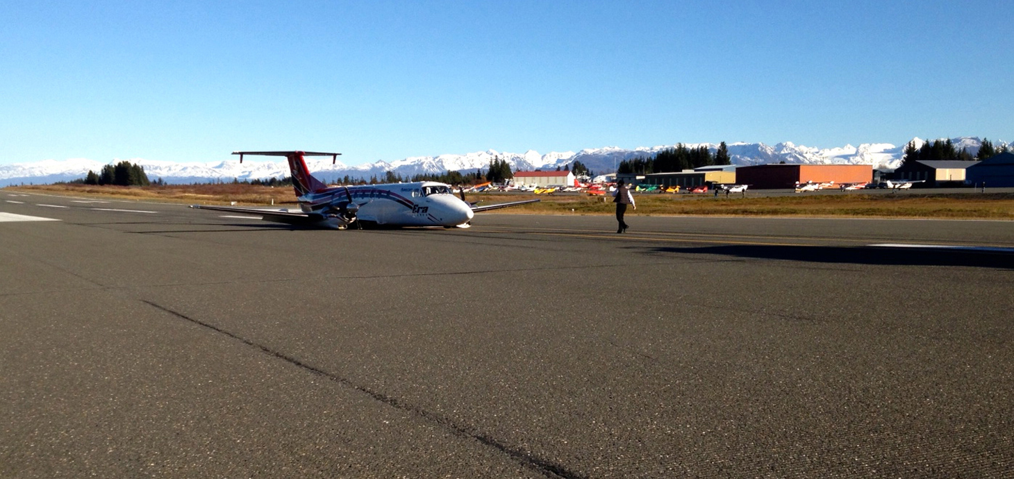 The Era Alaska Beechcraft 1900C airplane lies on the runway at the Homer Airport after skidding on its belly when the landing gear apparently collapsed.-Photo by Shelley Gill