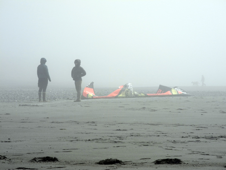 Beach walkers wait for kite surfers to hit the waves last Saturday as fog shrouds the Homer Spit during KiteFest.-Photo by Michael Armstrong, Homer News