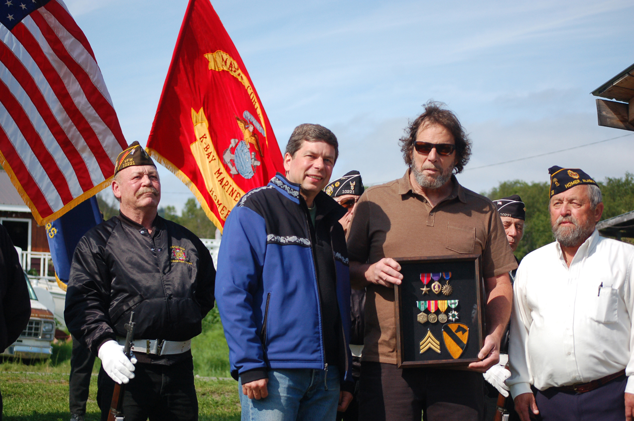Randy Clifford, center, poses with Sen. Mark Begich, D-Alaska, left, and American Legion Post 16 Commandant Richard Turner, right, after Begich presented Clifford with a duplicate set of medals to replace those lost after Clifford was wounded in Vietnam. Standing by them is an honor guard from Veterans of Foreign Wars Post 10221, Anchor Point.-Photos by Michael Armstrong, Homer News