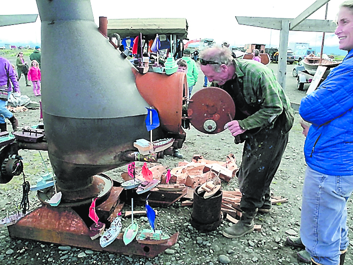 John Miles feeds the wood stove at the 2013 Kachemak Bay Wooden Boat Festival.