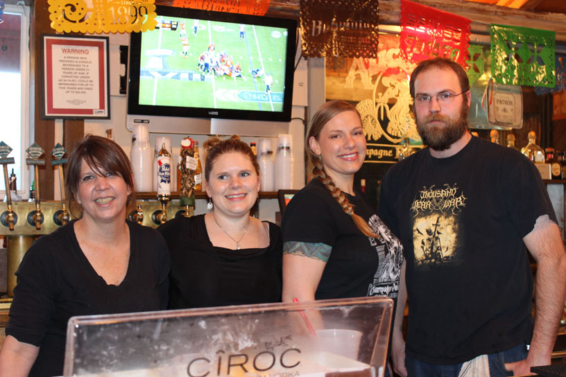 Keeping patrons happy before Alice’s Champagne Palace closed its doors on Sunday were servers Laura Duncan, Jill Gunnison and Nickie Knight, and bartender Dan Norton­.-Photo by McKibben Jackinsky, Homer News