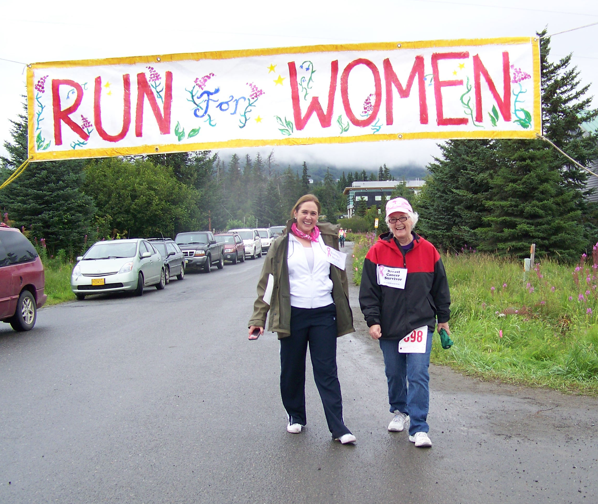 Breast cancer survivors Mary Johnson and Connie Prouty cross the finish line after completing the one-mile walk of Sunday's Breast Cancer Run.-Photo by McKibben Jackinsky,  Homer News