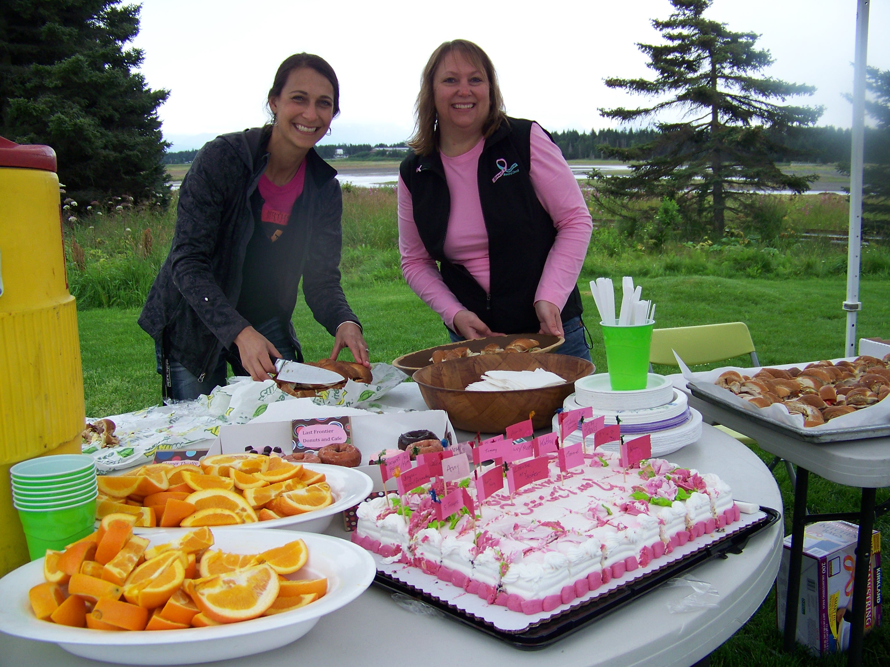 Megan Palma of Kachemak Bay Family Planning Clinic and Bobbi Unger of Breast and Cervical Health Check prepare refreshments for athletes at the end of Sunday's Breast Cancer Run.-Photo by McKibben Jackinsky,  Homer News