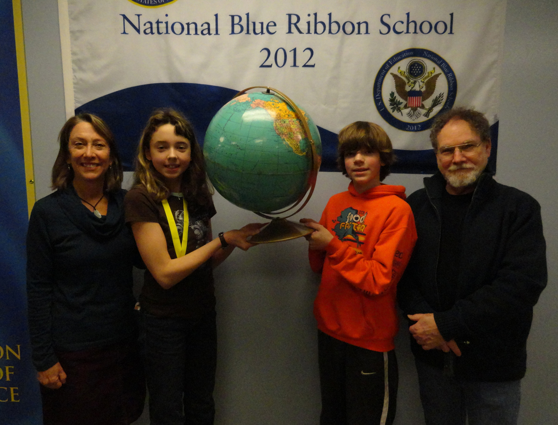 West Homer Elementary School sixth-grader Ellie Syth, second from left, won that school’s Geo Bee and classmate Caleb Rauch, second from right, is the runner-up. Suzanne Haines, left, helped cooridnate the event; Mike Hawfield, right, was the guest announcer. -Photo provided