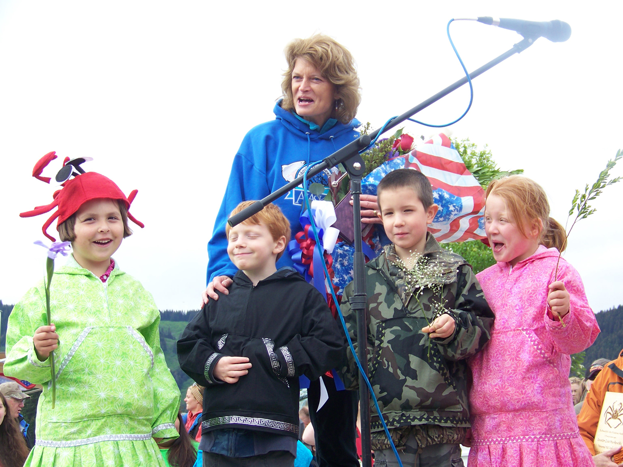 U.S. Sen. Lisa Murkowski receives flowers from Seldovia Village Tribe’s Sea Otter Dancers in Seldovia on July Fourth. The dancers are, from left, Helena Waterbury, Noah Glossi, Conner Ca meron and Nevaeh Morrison.-Photo by McKibben Jackinsky, Homer News