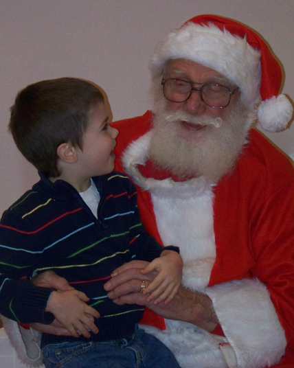 Brennan Steen and Santa share a ho-ho-ho at the Pratt Museum on Saturday.-McKibben Jackinsky,  Homer News