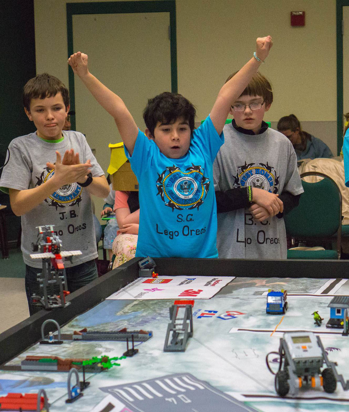 West Homer Elementary School “Lego Oreo” team members (from left) Josh Bradshaw, Sylvester Gaona and Ben Coble celebrate a successful move during Robotics competition on Saturday. Team members not pictured include Timberlee Davis, Katlin Cudaback and Aaron Toro. The team won the “Judges Choice” trophy.-Photo provided