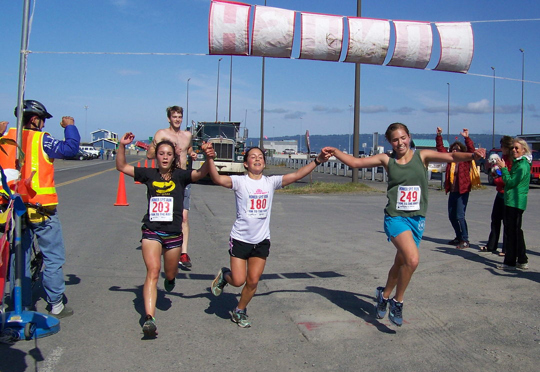 From left, Molly Mitchell, Barae Hirsch and Aurora Waclawski are the first women to cross the finish line of the 10K course from Homer High School to the end of