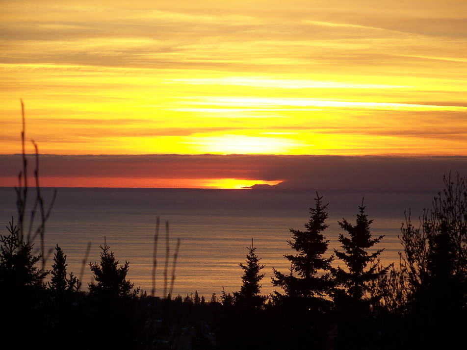 The winter sun sets over Cook Inlet earlier this week. Alaskans start getting more light beginning Monday.-Photo by McKibben Jackinsky, Homer News