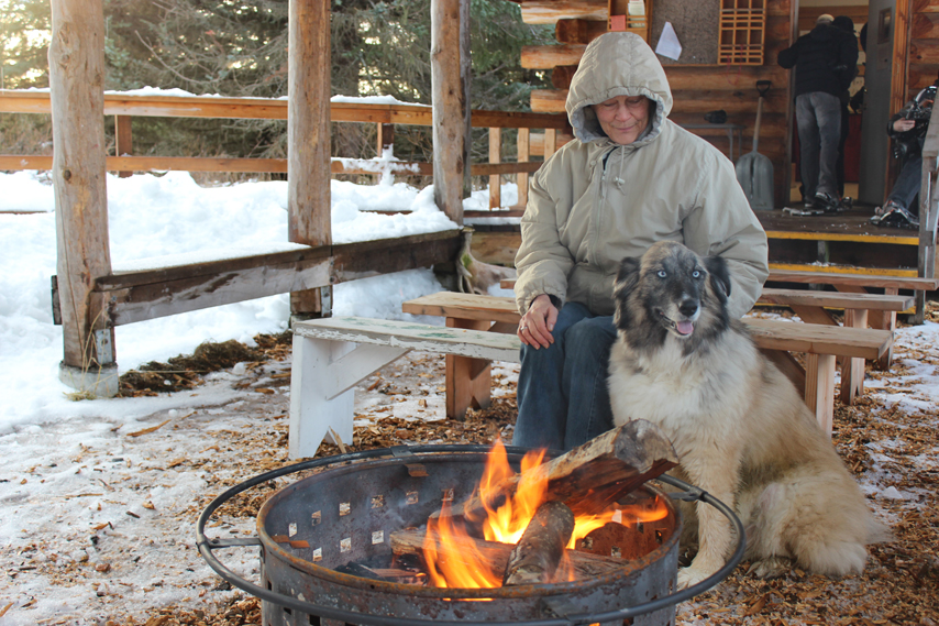 Valerie Young-Williams and her canine companion Matanuska enjoy the warmth of the bonfire at Center for Alaskan Coastal Studies’ Wynn Nature Center on Sunday.-Photo by McKibben Jackinsky, Homer News