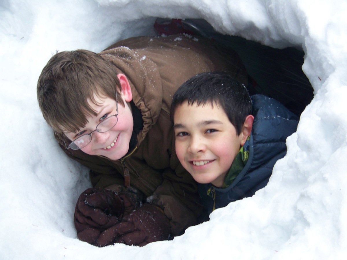 In the midst of a late-winter blizzard, West Homer Elementary School students Josiah Raymond and Noah Dabney are well-protected in a shelter they made at the Carl E. Wynn Nature Center.