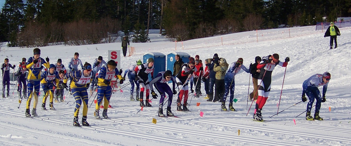 The blue-and-gold Homer Mariner boys cross-country ski team, left, and teams from Kenai, Skyview and SoHi, get a mass start at Borough competition at Lookout Mountain on Saturday.