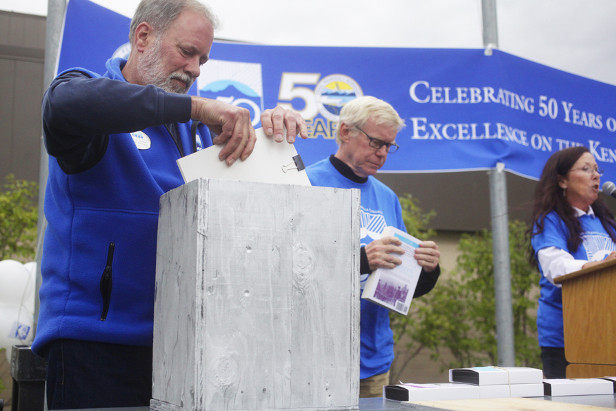 Peninsula College Direct Gary Turner places an item inside the mock-version of the 50th anniversary time capsule during the Kenai Peninsula Borough, Kenai Peninsula College and Kenai Peninsula Borough School District joint 50th anniversary community barbecue on Aug. 14 at the KPC Kenai River Campus, Soldotna.-Photo by Kelly Sullivan/Morris News Service Alska