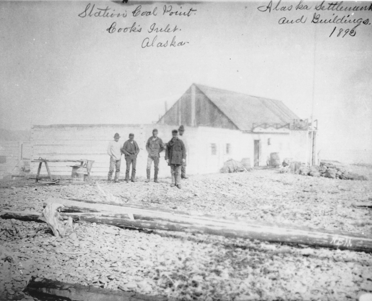 Several people stand by a building at Coal Point in 1892 on the Homer Spit, the first non-Native settlement there. -Photo provided, Pratt Museum