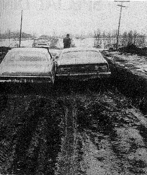An April 1976 Homer News photo shows two cars stuck in mud on East End Road.-Homer News file photos