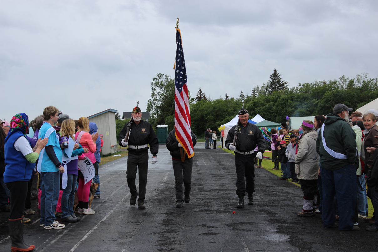 Each of them cancer survivors, a three-member honor guard from Veterans of Foreign Wars Post 10221 in Anchor Point complete the first lap of the Homer Middle School track.-Photo by McKibben Jackinsky, Homer News