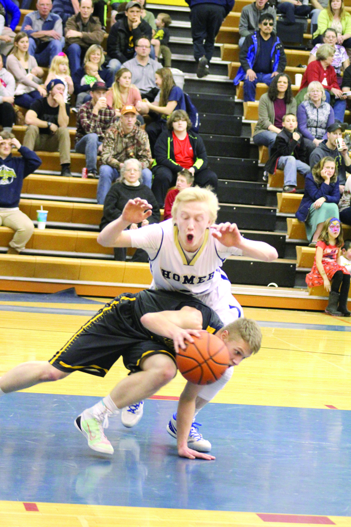 Mariner sophomore Charles Rohr dives over a Ninilchik player as he attempts to intercept the ball in the Feb. 13 Winter Carnival tournament game.-Photo by Anna Frost, Homer News