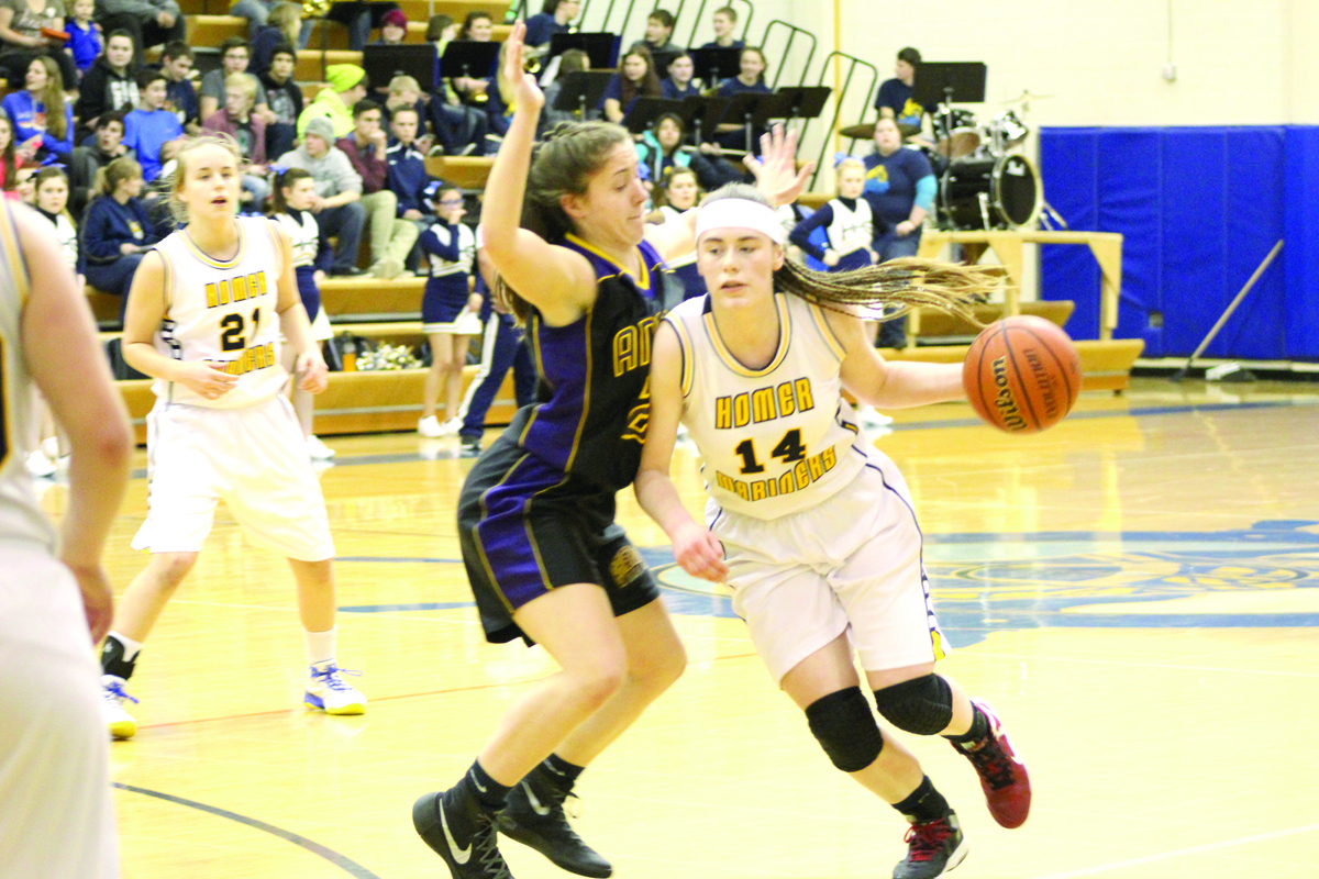 Madison Akers runs the ball to the basket, blocking an attempt at the ball by a Bristol Bay player, in the Feb. 12 Winter Carnival Tournament game.-Photo by Anna Frost, Homer News