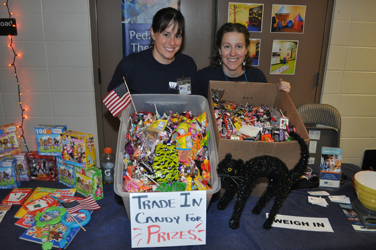 Jackie Forster and Amy Lower of the South Peninsula Hospital Pediatric Therapy Clinic stand by more than 100 pounds of trick-or-treat candy at the Great Candy Exchange at the health fair. The candy will be put in Christmas stockings sent to deployed Alaska National Guard members.-Photo by Maynard Gross