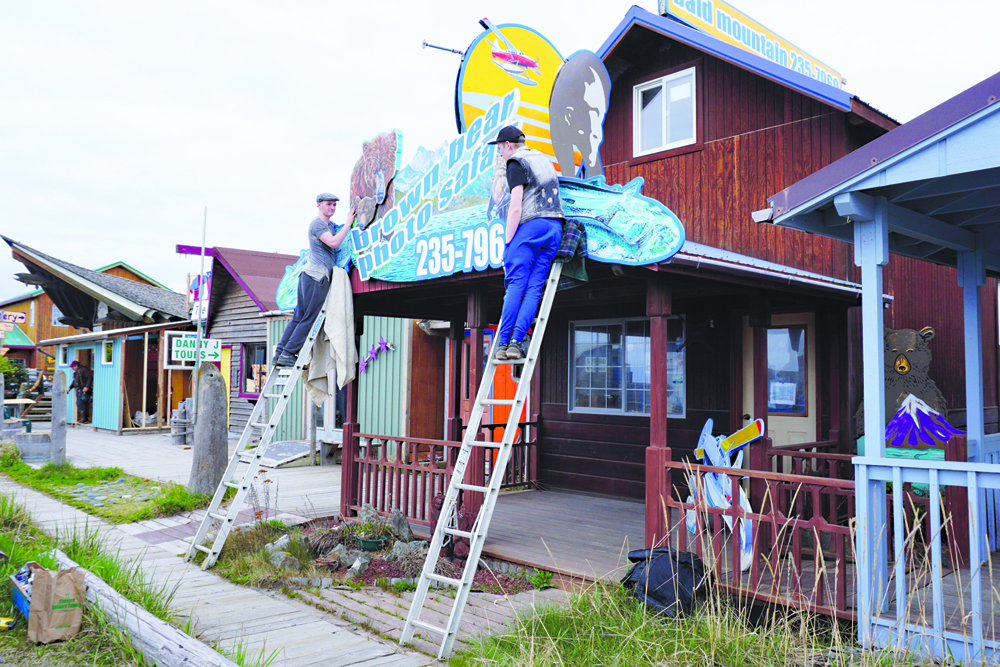 Activity on the Homer Spit indicates summer is near. Brothers Daniel Coe, left, and Josiah Coe install a sign at Bald Mountain Air on the Homer Spit on April 15. The brothers work for their dad, Dan Coe, whose  business is Handpainted Designs.