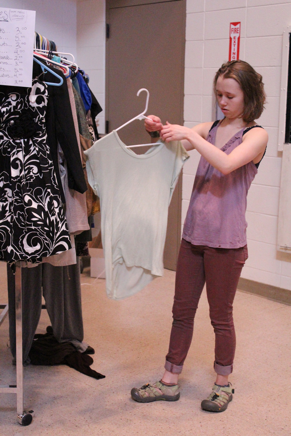 Shenandoah Lush inspects a shirt for sale at Colors of Homer. The Saturday, April 16 event sold donated clothing to raise money for the Homer High School art program in addition to the variety show featuring teens showing off their talents.-Photo by Anna Frost; Homer News
