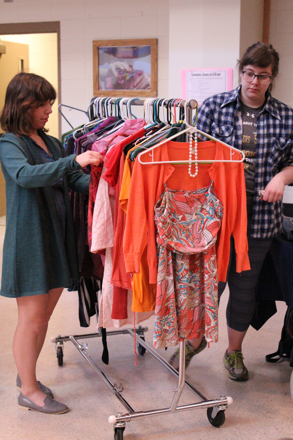 Lindsey Schneider and Drew Wimmerstedt (left to right) browse through a rack of clothing for sale at Colors of Homer on Saturday, April 16. -Photo by Anna Frost; Homer News