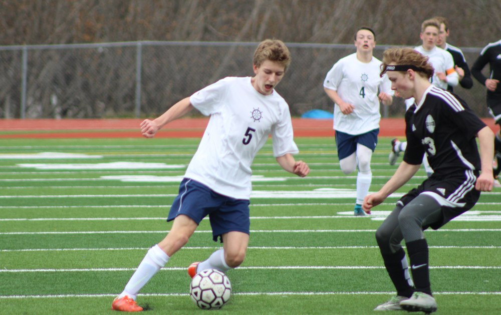 Simon Dye faces off against a Nikiski player for the ball during the Thursday, April 14 game held at Homer High School.-Photo by Anna Frost; Homer News