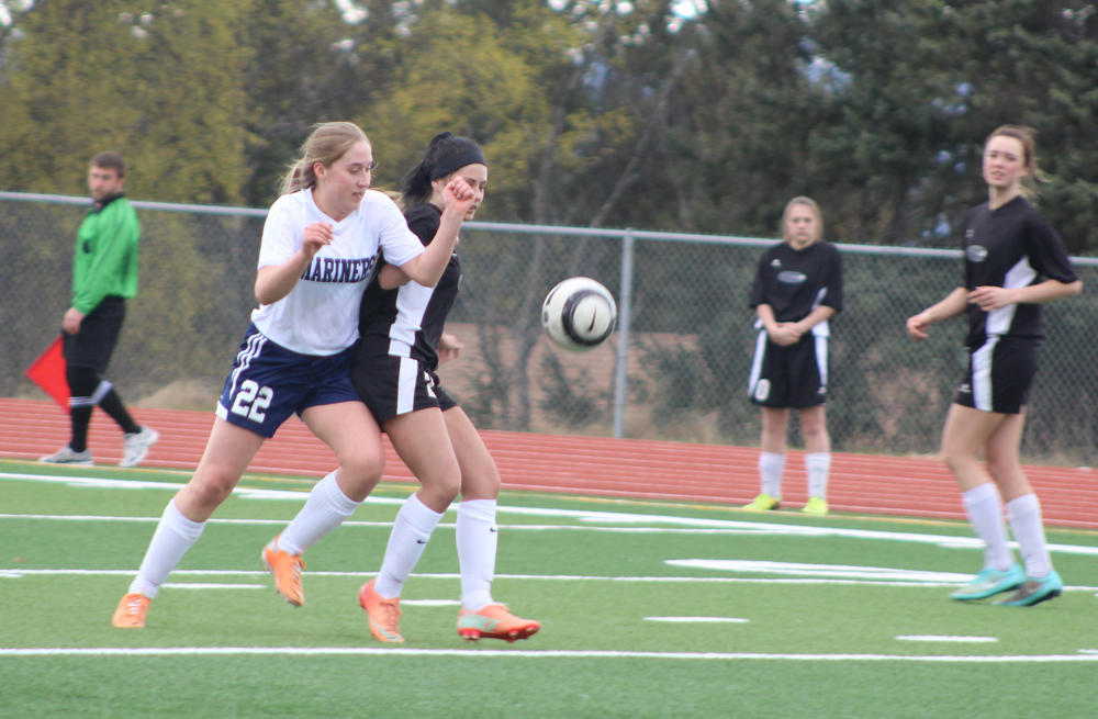 Brenna McCarron checks a Nikiski player as they both rush for the ball during the Thursday, April 14 game at Homer High School.-Photo by Anna Frost; Homer News