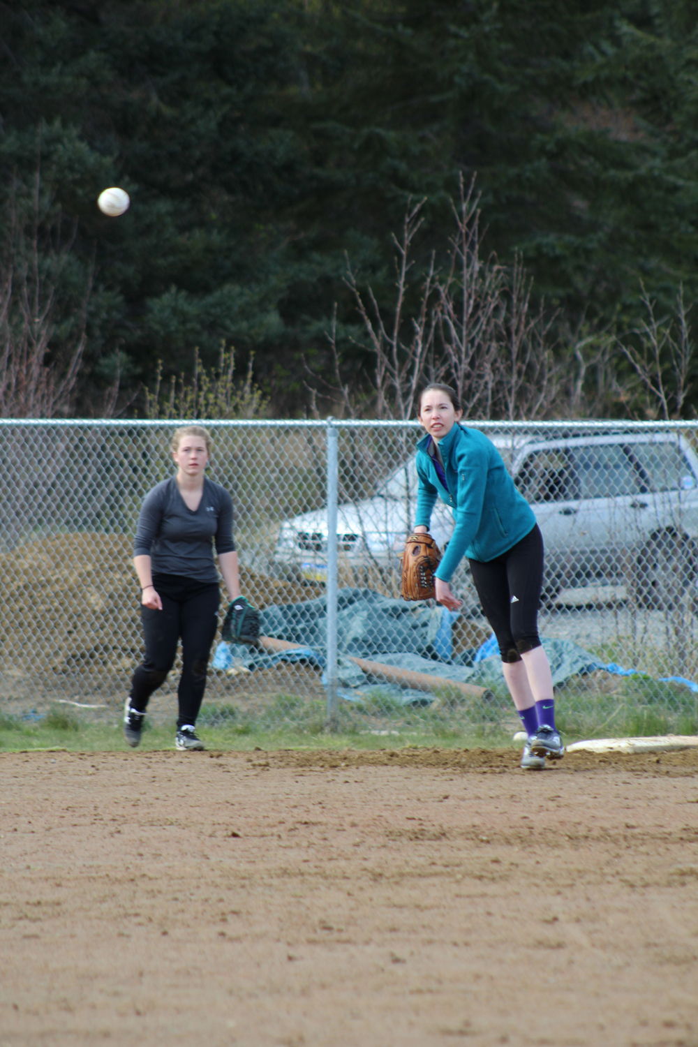 PK Woo throws the ball across the field during a throwing and catching drill at practice. The varsity softball team will play their first game of the season against Kenai Central High School on Tuesday, April 26.-Photo by Anna Frost; Homer News