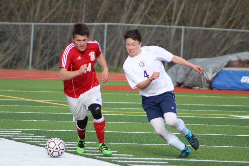 Homer sophomore Timothy Blakely charges at the ball in an attempt to keep it away from a his opponent during the April 26 home game against Kenai. Homer lost to Kenai, 5-1.-Photo by Anna Frost; Homer News