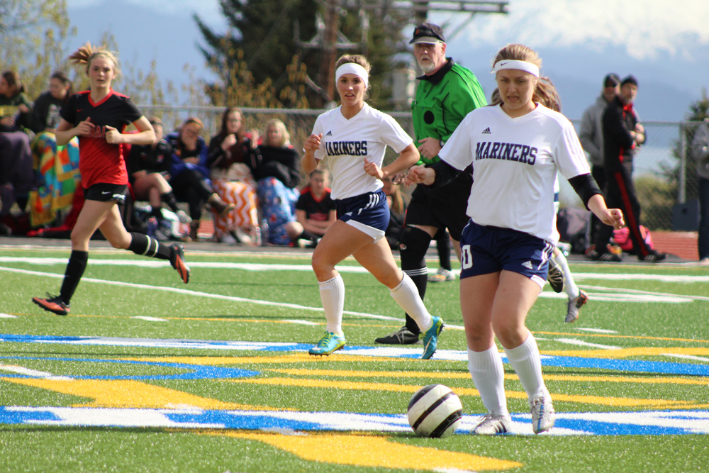 Rachel Ellert looks on as teammate Uliana Reutov takes control of the ball during the Mariner's Tuesday, April 26 home game against Kenai. The girls varsity team lost to Kenai, 5-1.-Photo by Anna Frost; Homer News