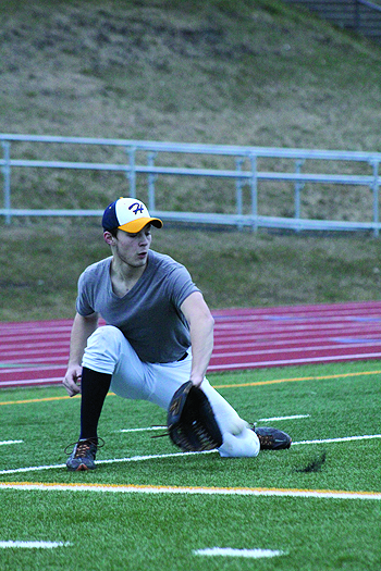 Kyle Johnson kneels down to catch a grounder during practice. The baseball team has been preparing for the start of their season since early March.-Photo by Anna Frost; Homer News
