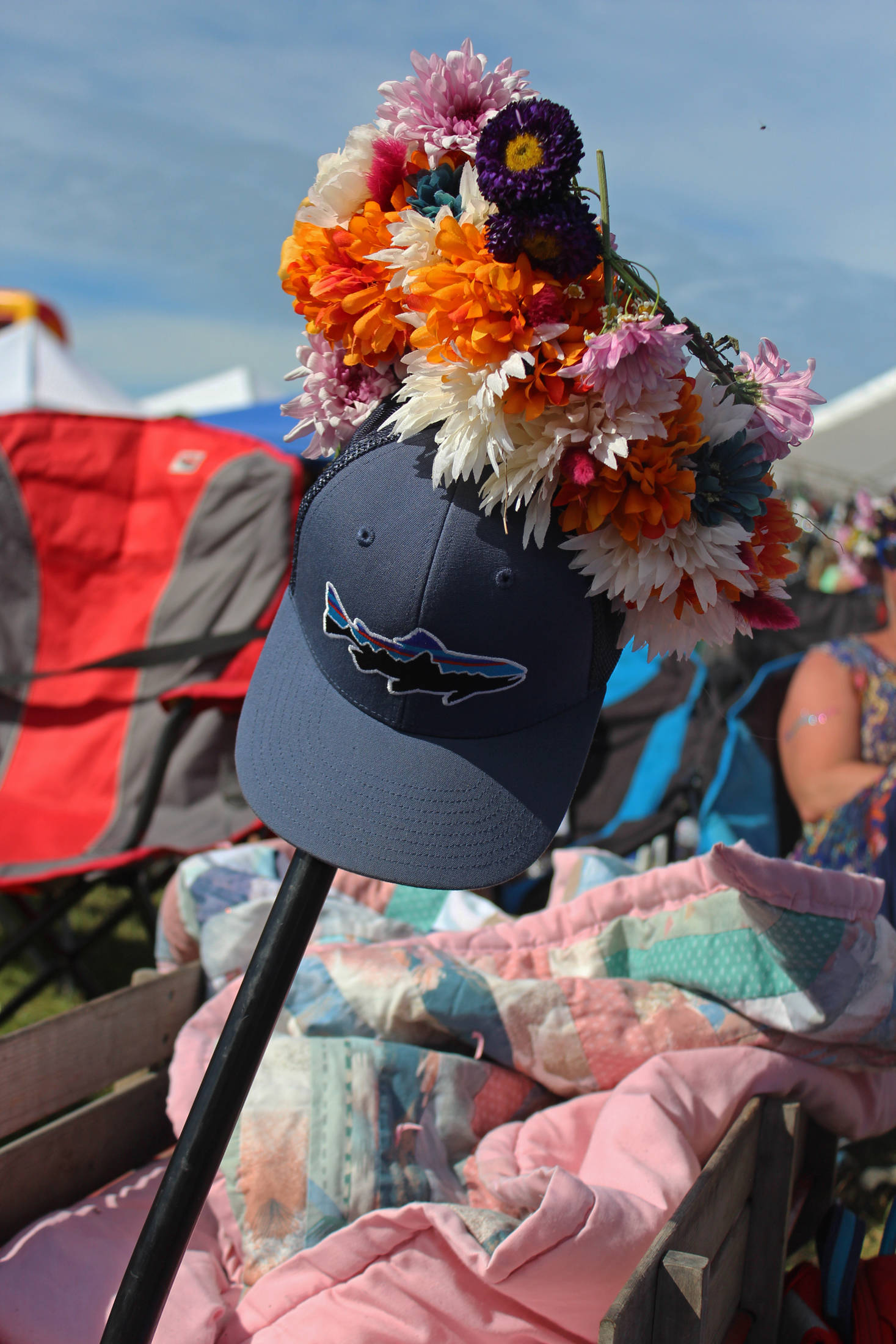 A hat decorated with peonies and other flowers sticks up out of a sea of lawn chairs, blankets, and relaxing festival goers during a performance at the Ocean Stage at this year’s Salmonfest on Saturday, Aug. 4, 2018 in Ninilchik, Alaska. (Photo by Megan Pacer/Homer News)