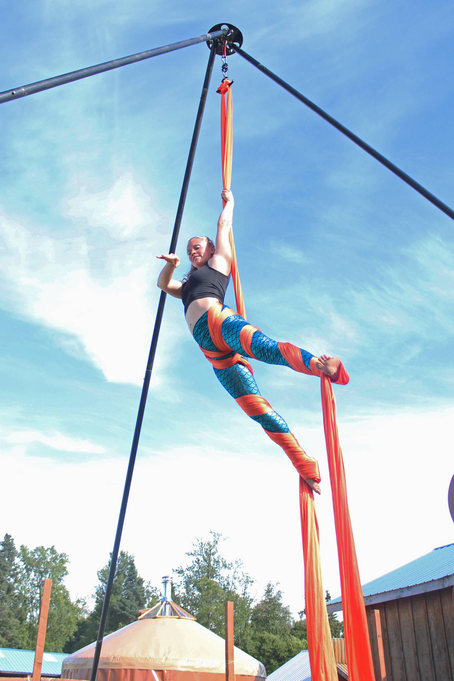 An aerial performer spins in the air next to the Ocean State at this year’s Salmonfest on Saturday, Aug. 4, 2018 at the Kenai Peninsula Fairgrounds in Ninilchik, Alaska. (Photo by Megan Pacer/Homer News)
